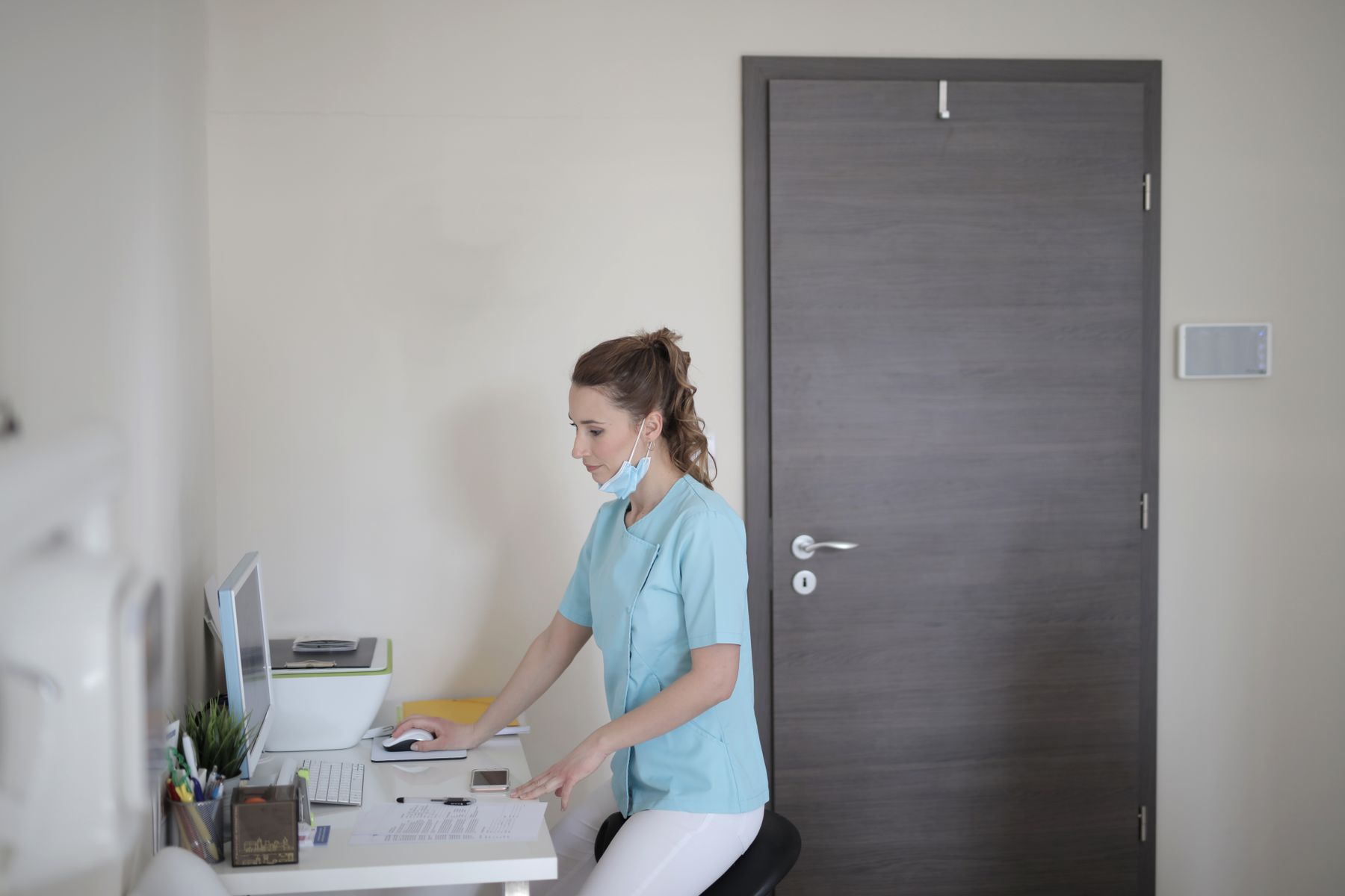 Clinical research professional working at a computer in a bright modern site office.